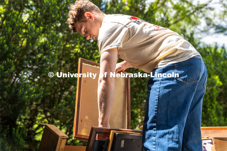 Alex Buescher of Phi Kappa Theta organizes a stack of picture frames by size during the Big Event. May 4, 2024. Photo by Kirk Rangel for University Communication.
